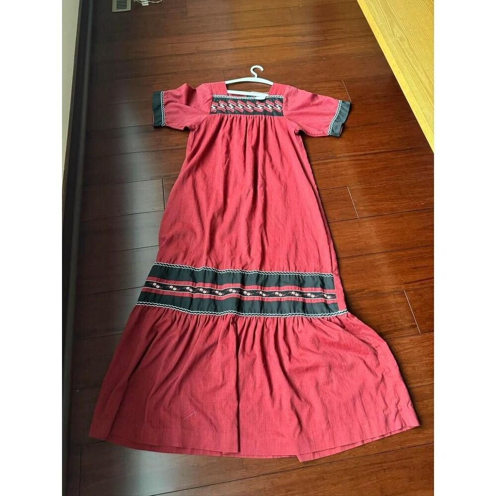 Vintage 1980s muumuu in a rich brick red with black embroidered trim